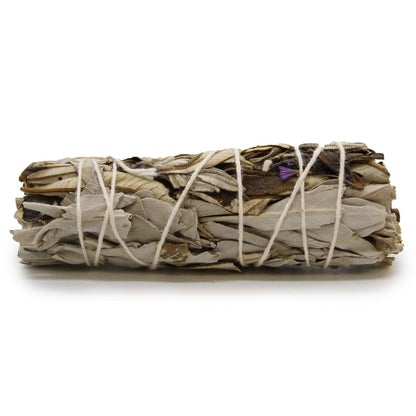 Bundled sage sticks tied with twine on a white background