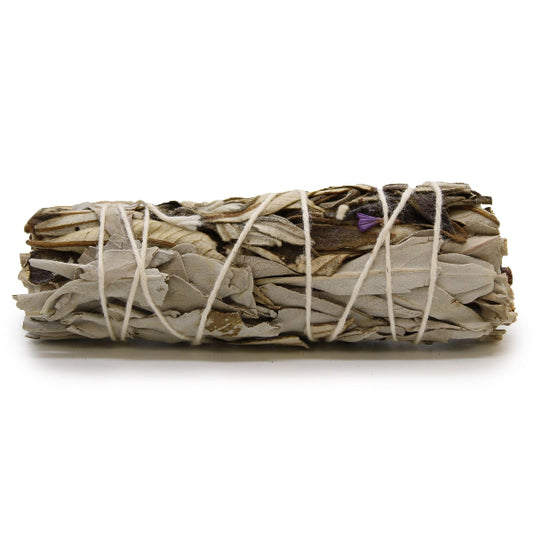 Bundled sage sticks tied with twine on a white background