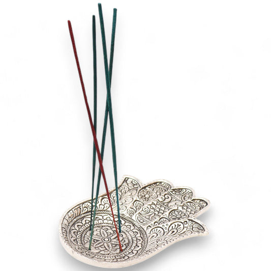 Decorative ceramic dish with incense sticks on a white background