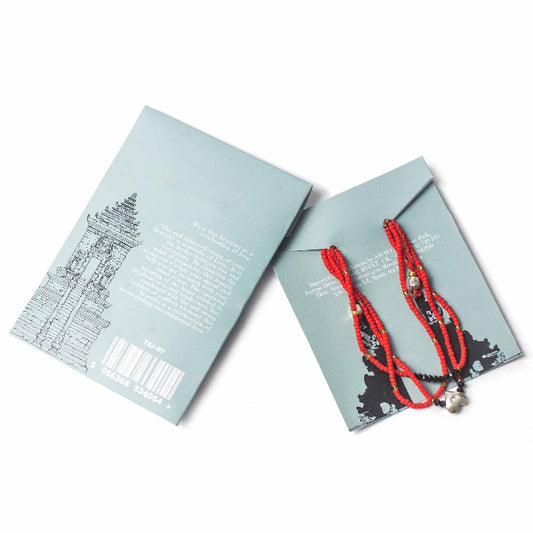 Red beaded necklace on a blue card with a white background