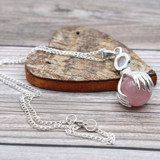 Necklace with a pink pendant on a wooden surface