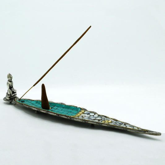 Decorative incense holder with turquoise base, gold accents, and a Buddha figure on a white background.