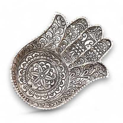 Decorative metal hamsa with intricate patterns on a white background