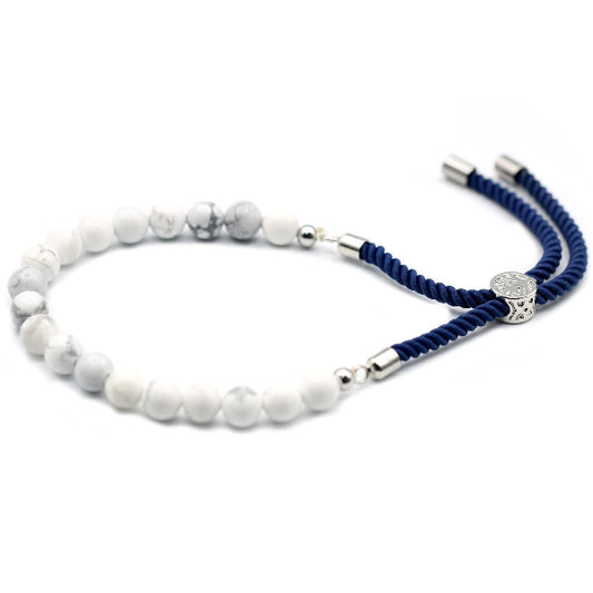 Bracelet with white beads and blue cord on a white background