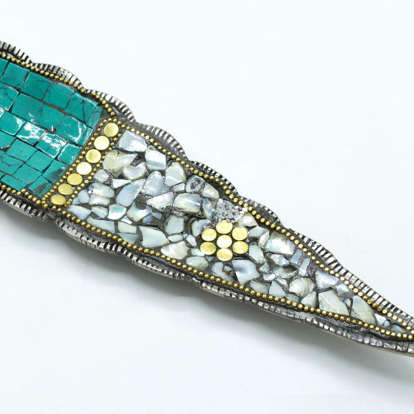 Decorative brooch with mosaic design on a white background