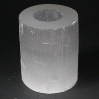 Clear cylindrical crystal on a black background
