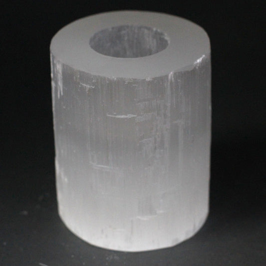 Clear cylindrical crystal on a black background