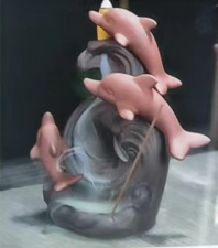Hand holding a bottle with a snake emerging, on a reflective surface.