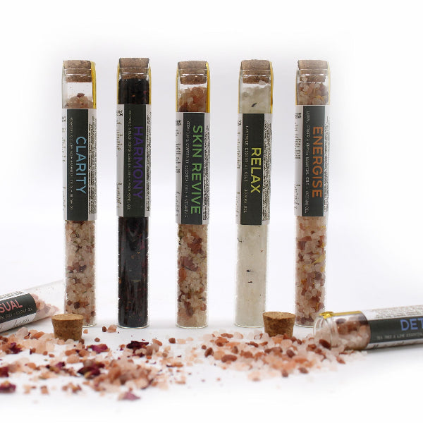 Five glass tubes with labels on a white background, containing different types of salt or spice blends.