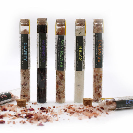Five glass tubes with labels on a white background, containing different types of salt or spice blends.