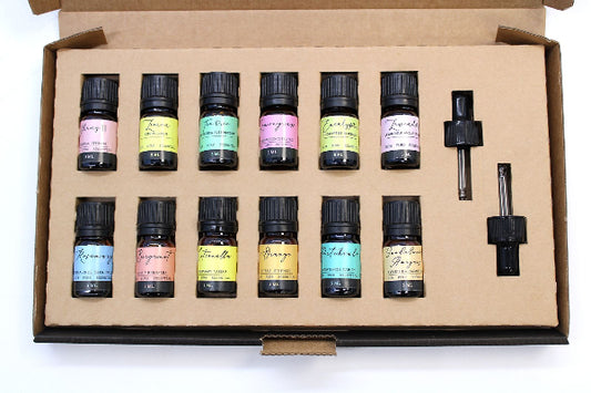 Set of essential oil bottles in a cardboard box on a white background