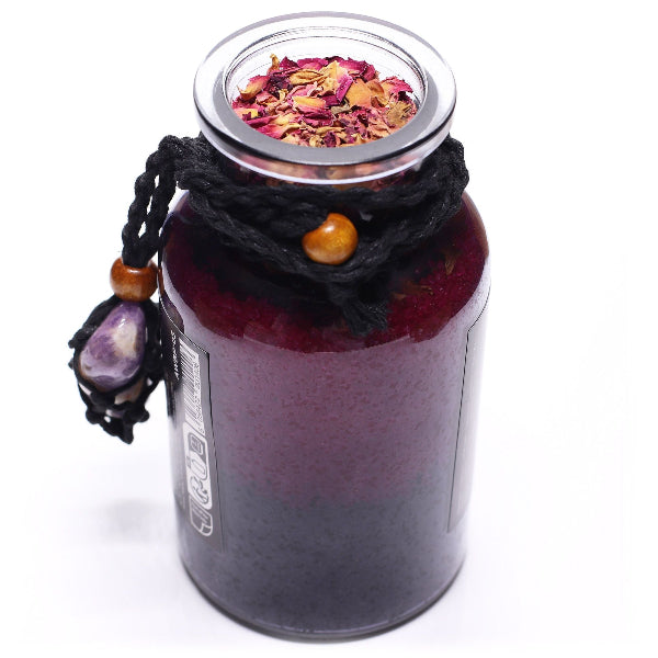 Glass jar with a lid filled with dried flowers, decorated with beads and stones on a white background