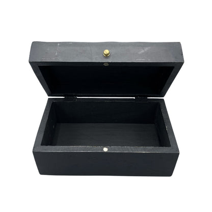 Black wooden box with a gold button on a white background