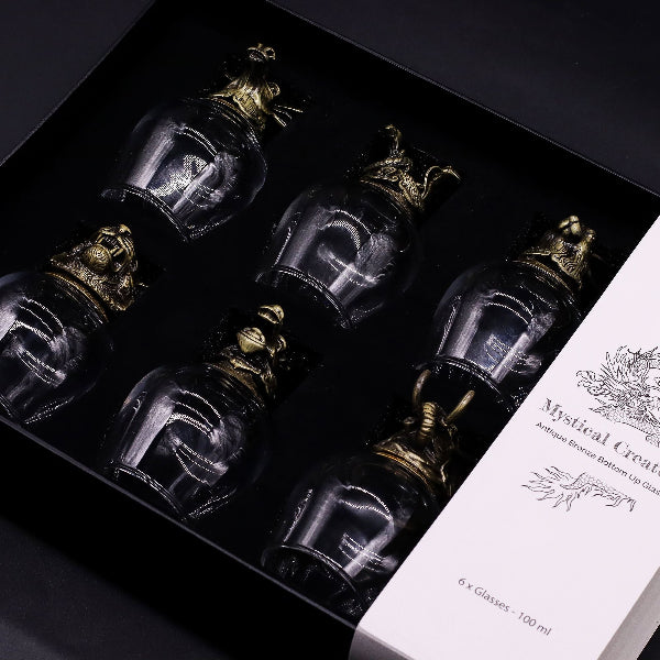 Set of glass bottles with decorative caps in a box, featuring the brand 'Mystical Creature'.