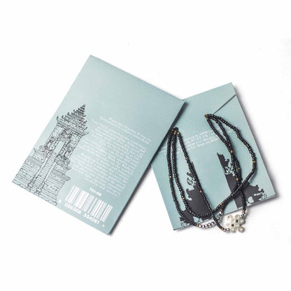 Necklace with skull pendant on a card with text and graphics