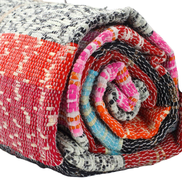 Rolled-up multicolored fabric with a mix of red, pink, blue, and gray patterns.