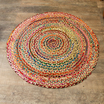 Round multicolored braided rug on a wooden floor