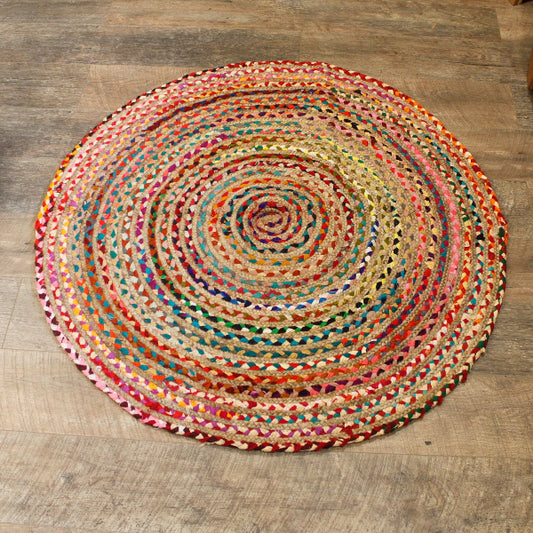 Round multicolored braided rug on a wooden floor