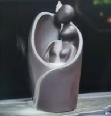Decorative sculpture of a couple in an embrace on a dark background