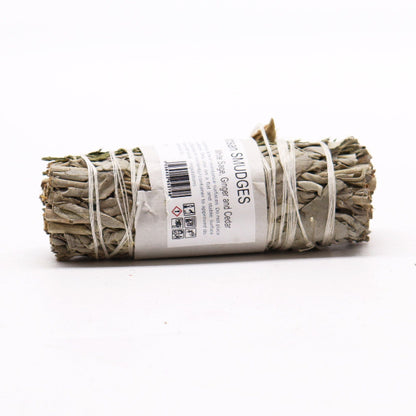 Rolled sage smudge stick with a label on a white background