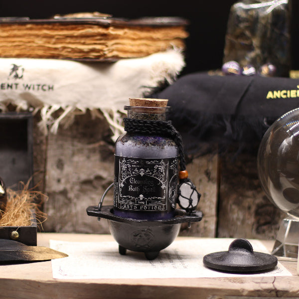 Decorative bottle with label on a rustic surface with witch-themed background