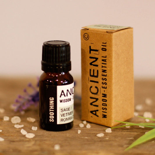 Bottle and box of Ancient Wisdom essential oil on a wooden surface with a blurred background