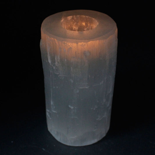 Cylindrical crystal with a warm glow on a black background