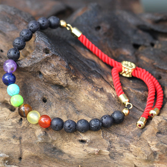 Necklace with multicolored beads and red cord on a wooden surface