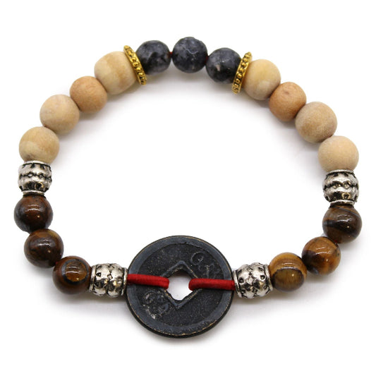 Beaded bracelet with various colored beads and a central black coin charm on a white background