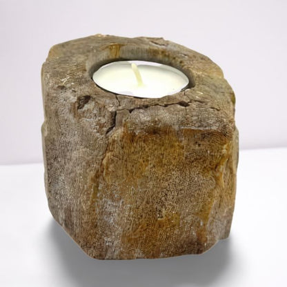 Candle holder made of natural stone with a white candle inside on a white background