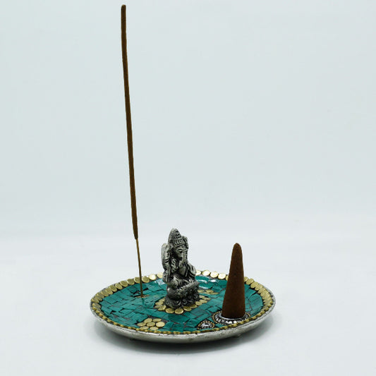 Incense burner with a decorative base and incense sticks on a light gray background