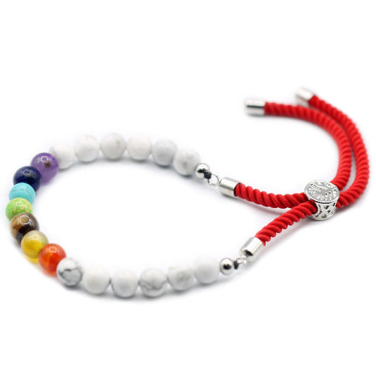 Bracelet with colorful beads and red cord on a white background