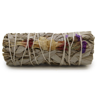 Rolled sage bundle with colorful leaves tied with twine on a white background