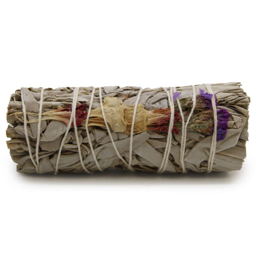 Rolled sage bundle with colorful leaves tied with twine on a white background