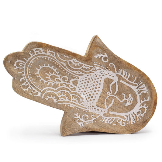Wooden decorative item with intricate white patterns on a white background