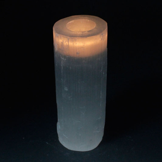 Clear cylindrical crystal with a glowing interior on a black background