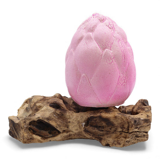 Pink textured object on a wooden base against a white background