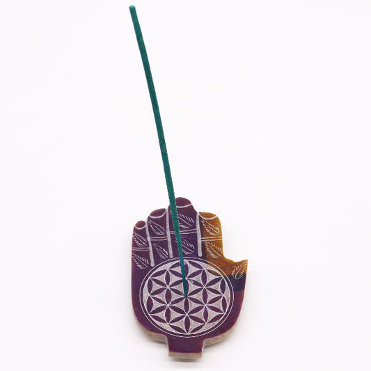 Incense holder shaped like a hand with a floral design on a white background