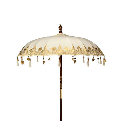 Decorative umbrella with tassels and heart shapes on a white background