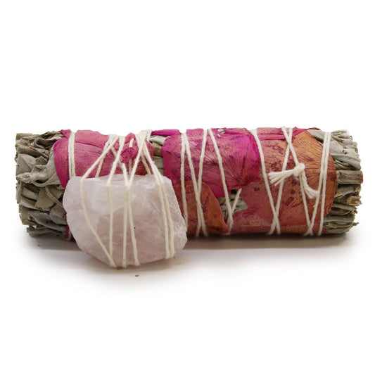 Sage bundle wrapped with pink fabric and white string on a white background