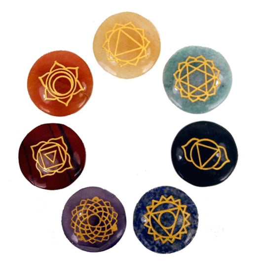 Set of seven chakra stones with gold symbols on a white background