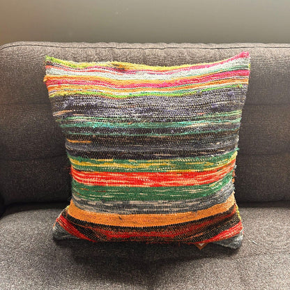 Multicolored striped pillow on a gray sofa