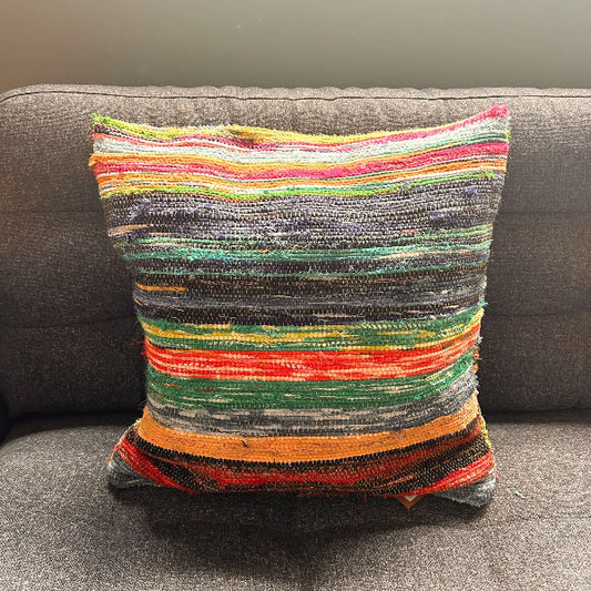 Multicolored striped pillow on a gray sofa