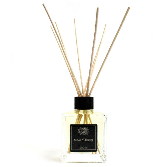 Reed diffuser with wooden sticks and a black cap on a white background