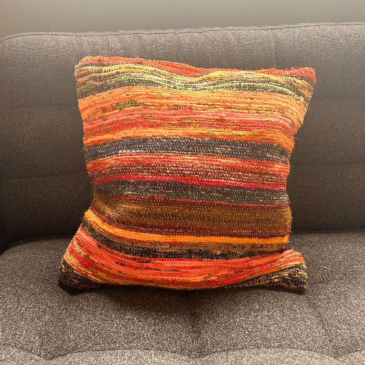 Multicolored striped pillow on a gray couch