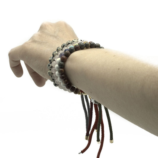 Hand wearing a bracelet with beads on a white background