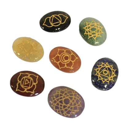 Set of seven stones with gold symbolic designs on a white background