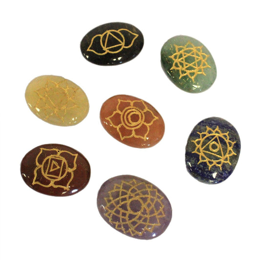 Set of seven stones with gold symbolic designs on a white background