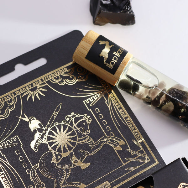 Black and gold packaging with a horse design and a rolled-up paper or card on top.