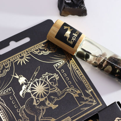 Black and gold packaging with a horse design and a rolled-up paper or card on top.